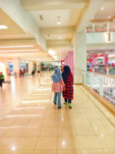 Two Indonesian hijab women are walking at the mall.