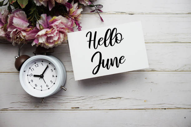 istock Hello June text message with flower and alarm clock on wooden background 1491640333