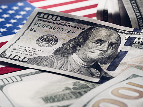 Moneda monetaria mundial estadounidense 100 dólares en el fondo de la bandera estadounidense. Las empresas y la crisis mundial photo