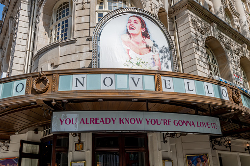 London. UK- 05.17.2023.The name sign and facade of the Novello Theatre in Aldwych with an advertisement for the musical Mama Mia!