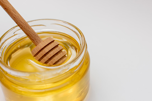 Wooden spoon for honey in a jar with honey