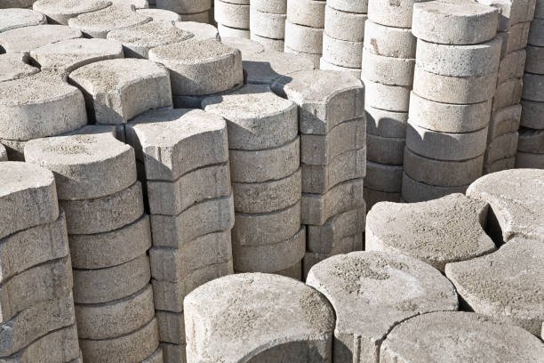 Stack of concrete self locking flooring blocks in curved shape on wooden pallet in a construction site - used in construction industry to create permeable floors to rain water on a layer of sand pila de bloques de pisos autoblocantes de concreto en forma curva en una plataforma de madera en un sitio de construcción, utilizada en la industria de la construcción para crear pisos permeables al agua de lluvia sobre una capa de arena