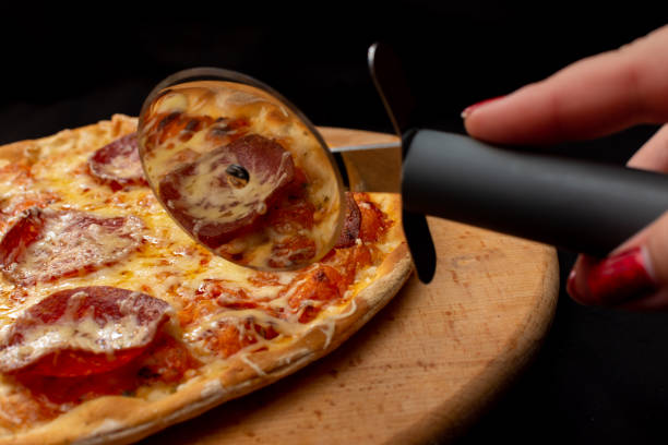 istock Cut the pizza with a special pizza cutter knife 1491643585