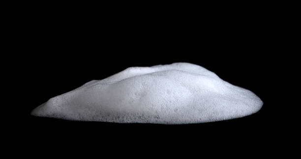istock White liquid foam from white soap on black background. 1491645020