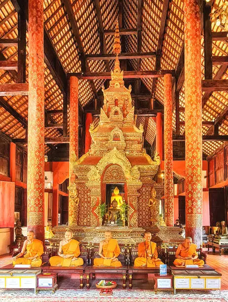 The life-like figures of revered monks in wax in front of the mondop of Ubosot of Wat Phra Singh