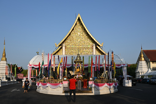 Chiangmai, Thailand - May 20, 2023:\nthe tourist comes to worship at the event at the main chapel.\n\nCeremony of wearing flower bowls to worship Inthakhin pillars (Chiang Mai City Pillar) for the year 2023, a merit-making event that has been inherited for a long time. Chiang Mai people will worship Inthakhin at the end of the 8th month, the 9th month, or between May and June.\n\nThis year, held on May 16-22, 2023 and May 23, 2023, is a merit-making day at Wat Chedi Luang Worawihan. Mueang Chiang Mai District Chiang Mai Province