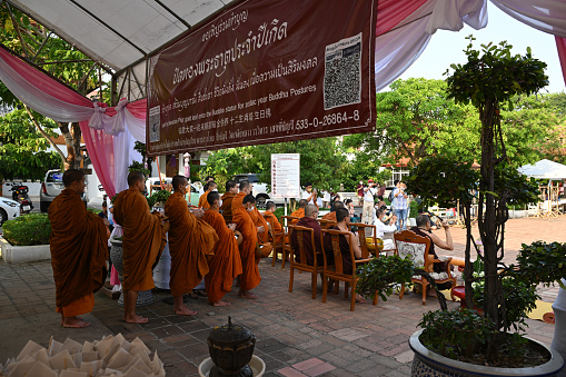 Chiangmai, Thailand - May 20, 2023: monks in line to receive food offerings from people in this event.\n\nCeremony of wearing flower bowls to worship Inthakhin pillars (Chiang Mai City Pillar) for the year 2023, a merit-making event that has been inherited for a long time. Chiang Mai people will worship Inthakhin at the end of the 8th month, the 9th month, or between May and June.\n\nThis year, held on May 16-22, 2023 and May 23, 2023, is a merit-making day at Wat Chedi Luang Worawihan. Mueang Chiang Mai District Chiang Mai Province