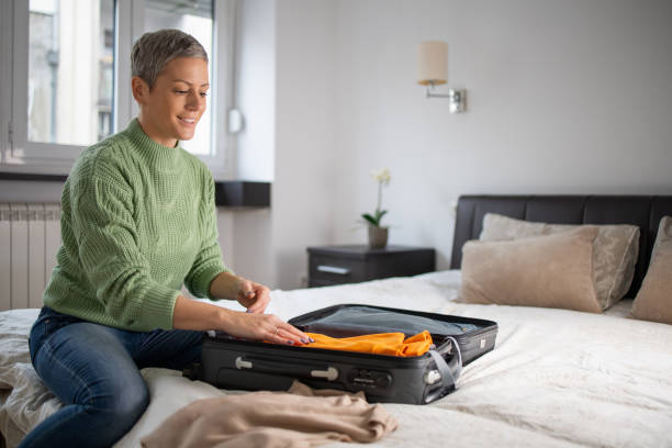 istock Mid adult woman packing suitcase 1491646795