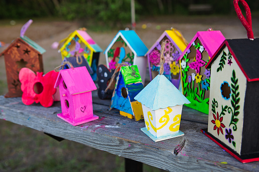 Children’s painted birdhouse on park bench at summer camp