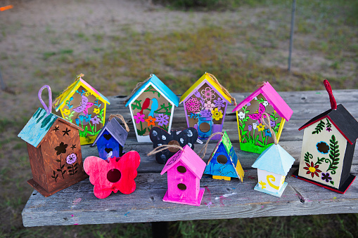 Children’s painted birdhouse on park bench at summer camp