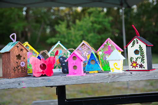 Children’s painted birdhouse on park bench at summer camp