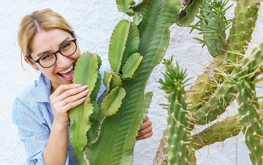 Young beautiful woman posing with a large cactus tree