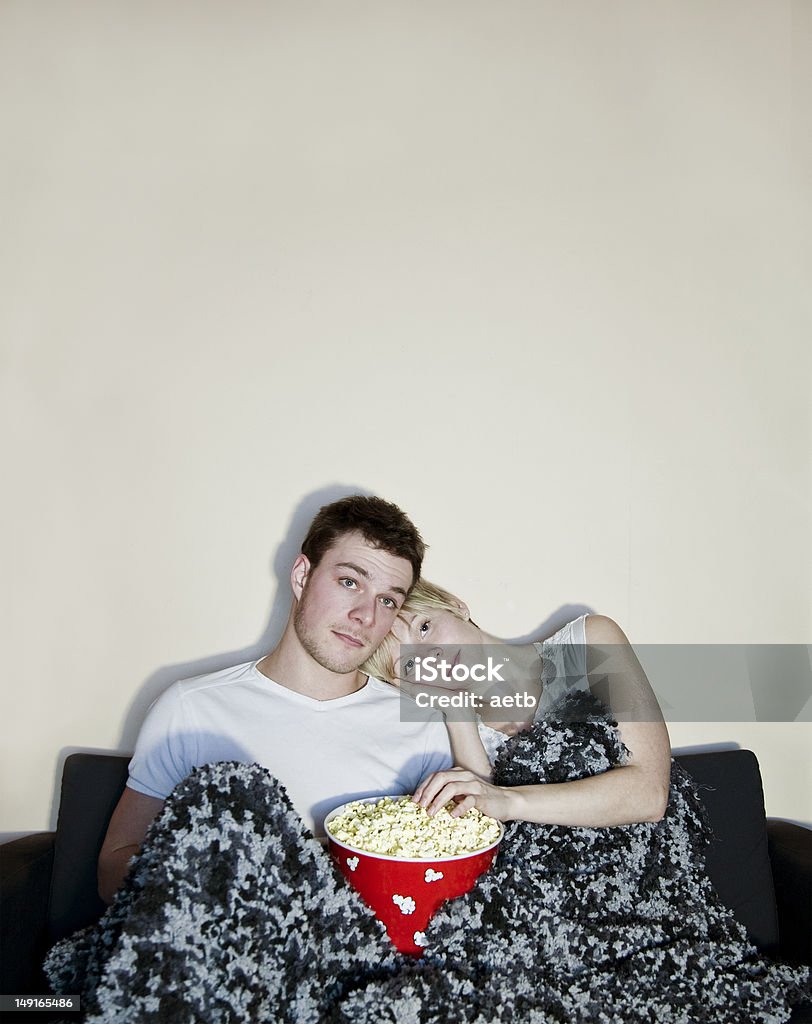 Jeune couple regarder la télévision avec pop-corn et manger - Photo de Pop-corn libre de droits