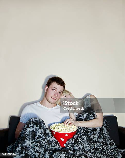 Foto de Jovem Casal Assistindo Televisão E Comer Pipoca e mais fotos de stock de Casal - Casal, Pipoca, Assistir TV