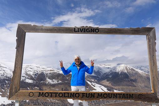 Vital senior, portrait  gray-haired men snow skier, enjoying on  ski resorts. Italian and Swiss border Alps  ski area. Ski resort Livigno. italy, Europe.