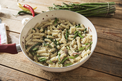 Simple fusilli pasta with asparagus in cooking pan