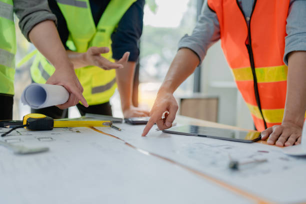istock multi ethnic engineer brainstorming and measuring for cost estimating on paperworks and floor plan drawings about design architectural and engineering for houses and buildings 1491663931