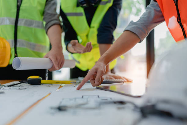 istock multi ethnic engineer brainstorming and measuring for cost estimating on paperworks and floor plan drawings about design architectural and engineering for houses and buildings 1491663969