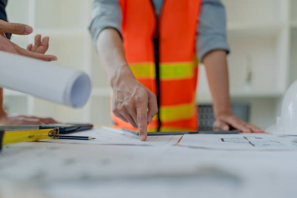 istock multi ethnic engineer brainstorming and measuring for cost estimating on paperworks and floor plan drawings about design architectural and engineering for houses and buildings 1491664020