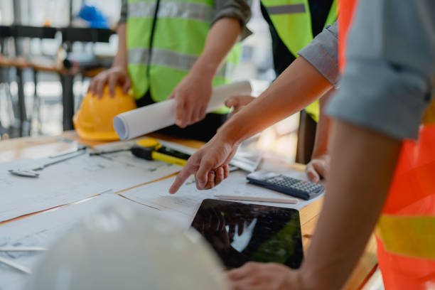 istock multi ethnic engineer brainstorming and measuring for cost estimating on paperworks and floor plan drawings about design architectural and engineering for houses and buildings 1491664047