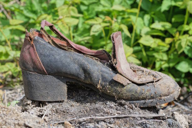 istock one old torn brown black dirty shoe stands on gray ground 1491676331