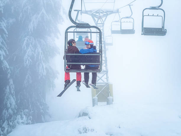 Junge multirassische Skifahrer lächeln auf Skilift, nebliger Tag – Foto