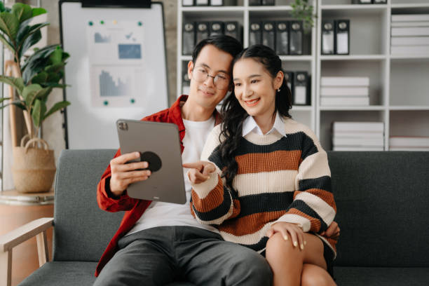 istock Two asian students learning together online with a laptop, tablet and tutor together in liveing room at home. 1491680753