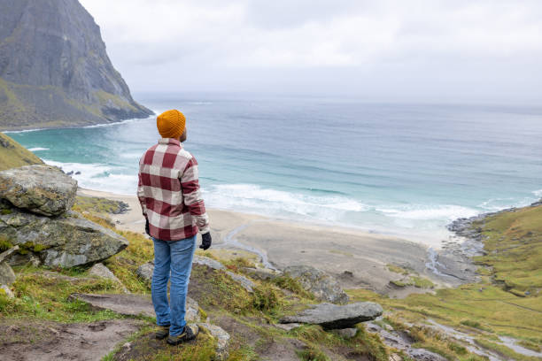 istock Hiker contemplates the beautiful nature in Norway, pristine beach view 1491680810
