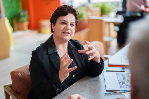 istock Businesswoman talking to a businessman, using portable information devices and documents. 1491681845