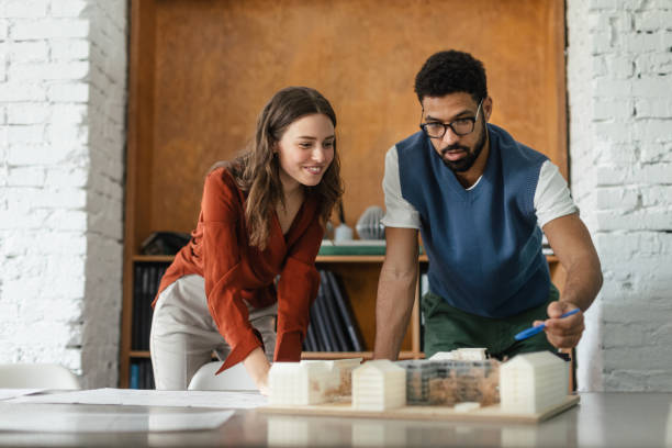 istock Young couple working as architects in the office. 1491683247