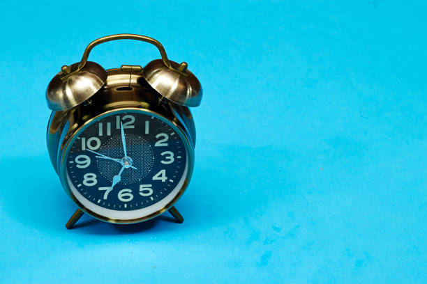 istock alarm o'clock showing 7 o'clock isolated on blue background 1491683635