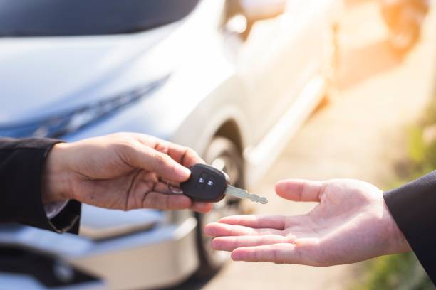 exchange handing over the car keys for to a young businessman. stock photo