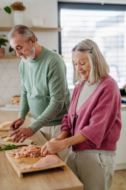 istock Senior couple cooking together in their kitchen. 1491684107