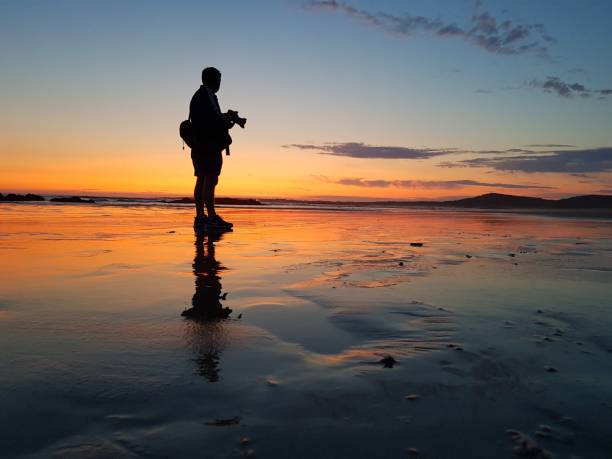 istock silhouette photographer man at sunset on the beach 1491686563