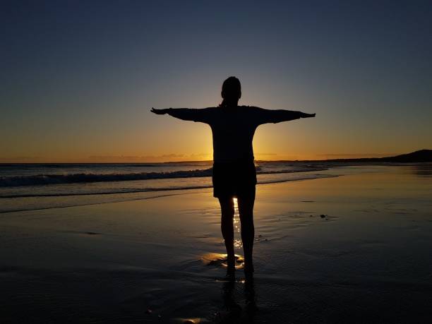 istock woman silhouette at sunset on the beach 1491686569