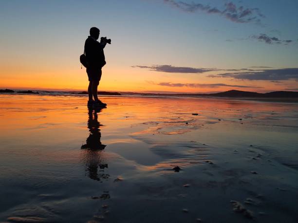 istock silhouette photographer man at sunset on the beach 1491686577