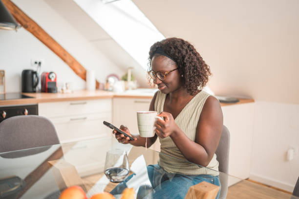 istock Cheerful Black Female Using Phone While Enjoying Her Coffee In The Morning 1491687880