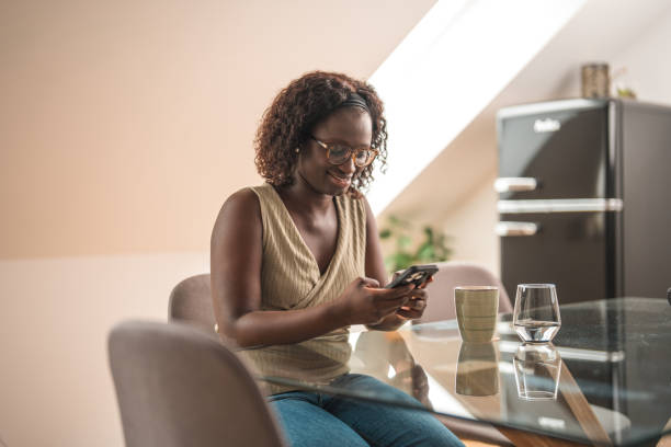 istock Black Female Text Messaging While Sitting In A Domestic Room 1491687948