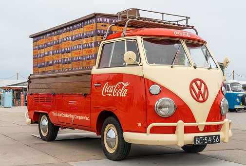 1950s Volkswagen Bus or Kombi Samba or Sunroof Deluxe classic camper van car. The Samba was the most luxurious Volkswagen Transporter first generation T1. The car is driving through the country.