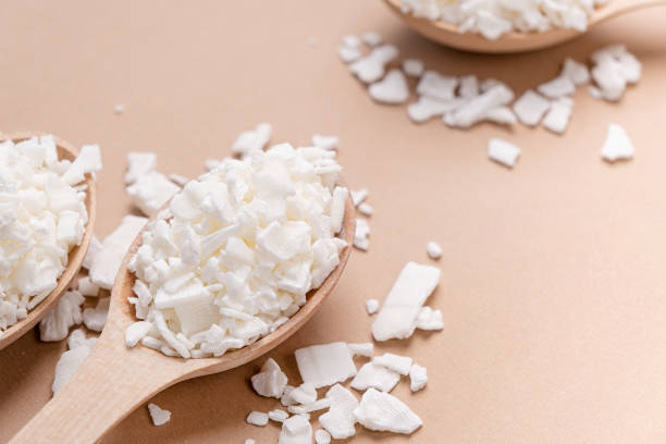 istock soy wax in wooden spoon on brown background, copy space 1491693711