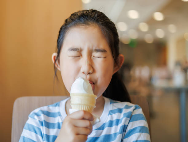 Little Girl Eating Ice Cream Little Girl Eating Ice Cream chinese ethnicity china restaurant eating stock pictures, royalty-free photos & images