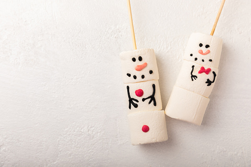 Cute Snowman with Gift against Snowy Background for Christmas