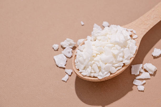 istock soy wax in wooden spoon on brown background, copy space 1491697215