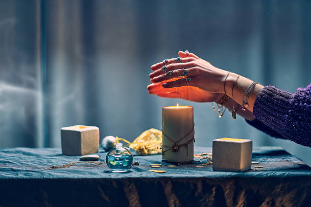 istock Witch woman using candles flame for magic spell during mystical witchcraft and divination 1491698636