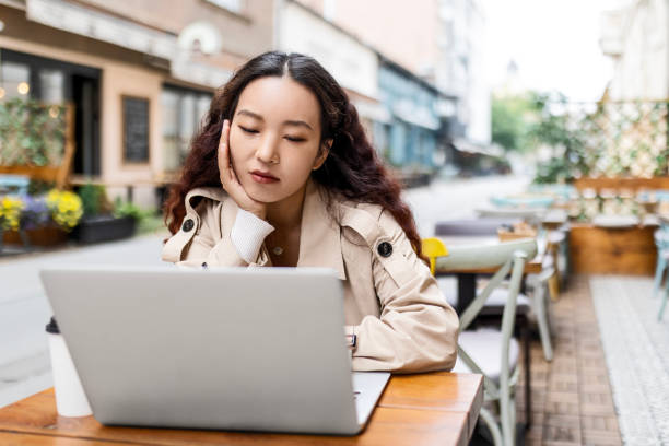 istock Chinese young woman using laptop in coffee shop 1491699021