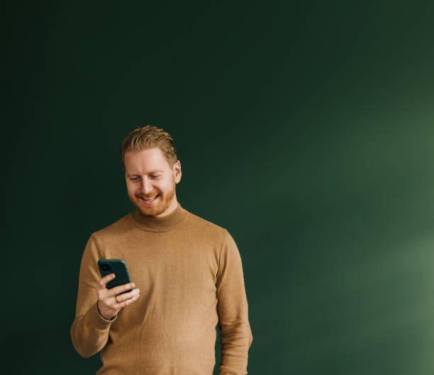 A Happy Handsome Blond Businessman Texting On His Mobile Phone