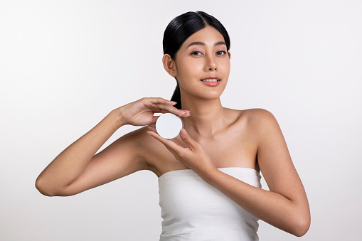 Attractive young Asian woman posing with beauty product in her hand