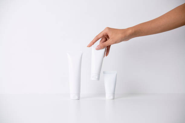 istock Woman picking up beauty product on white background 1491703018