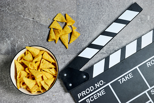 clapper board of video cinema in studio and  bowl of cone corn chips  on gray grunge background