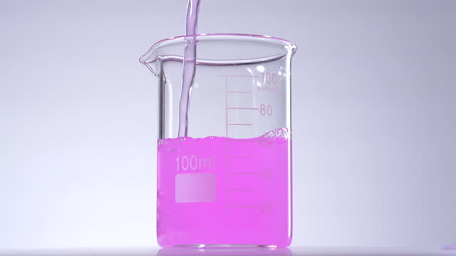 Pouring pink liquid solution in beaker